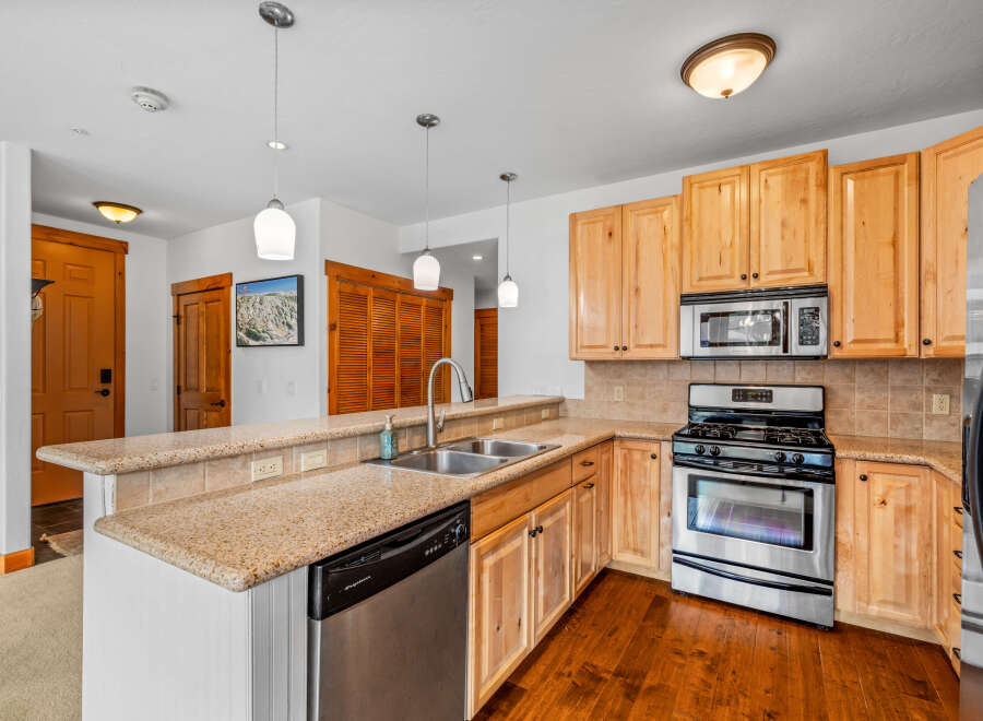 This charming kitchen features light wood cabinetry and granite countertops, offering a warm and inviting atmosphere.