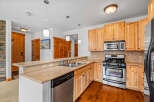 This charming kitchen features light wood cabinetry and granite countertops, offering a warm and inviting atmosphere.