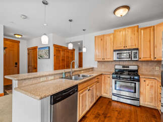 This charming kitchen features light wood cabinetry and granite countertops, offering a warm and inviting atmosphere.