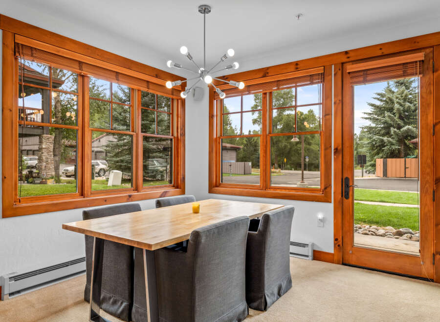 Enjoy meals in this bright dining area, featuring a natural wood table and comfortable upholstered chairs.