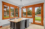 Enjoy meals in this bright dining area, featuring a natural wood table and comfortable upholstered chairs.