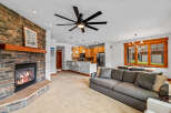 Cozy living room featuring a stone fireplace with a wooden mantel and a large gray sectional sofa.