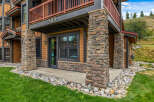 Experience mountain living in this charming property featuring a rustic stone facade and warm wood siding.