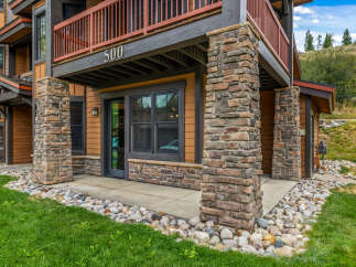 Experience mountain living in this charming property featuring a rustic stone facade and warm wood siding.