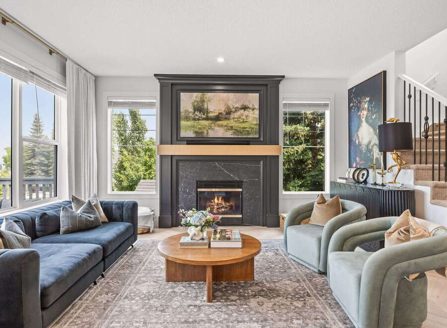 Experience luxury living in this stunning living room, featuring a grand fireplace as the centerpiece and expansive windows offering breathtaking views.