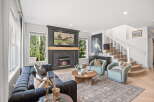 Experience luxurious living in this stunning living room, featuring a grand fireplace with a marble surround and a captivating landscape painting above.