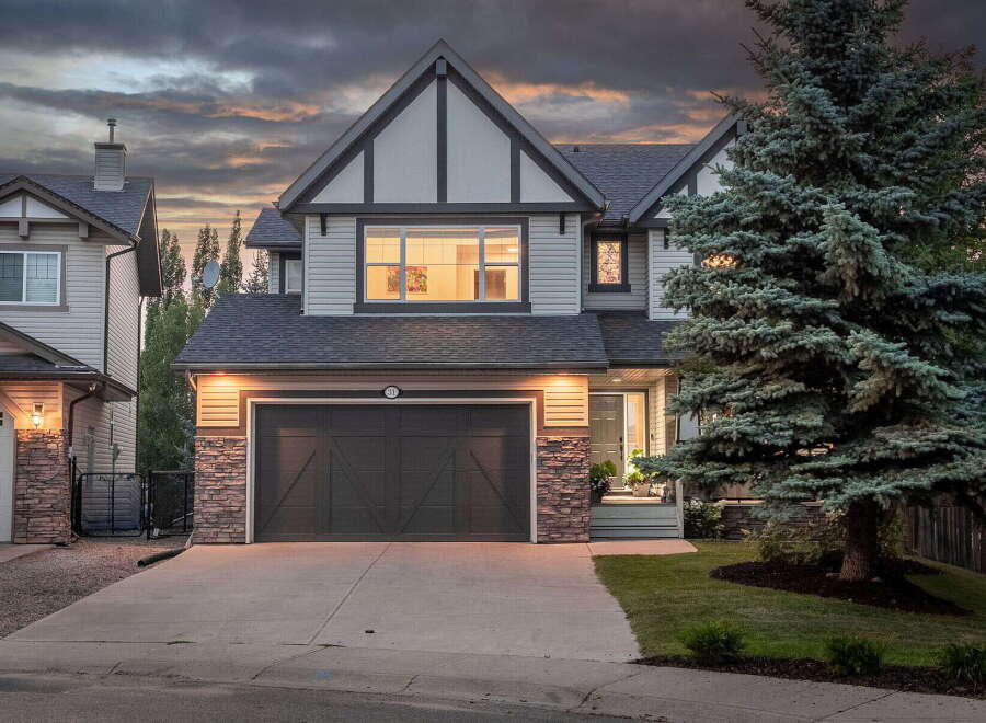 This stunning two-story home features a modern exterior with stone accents and a spacious double garage.