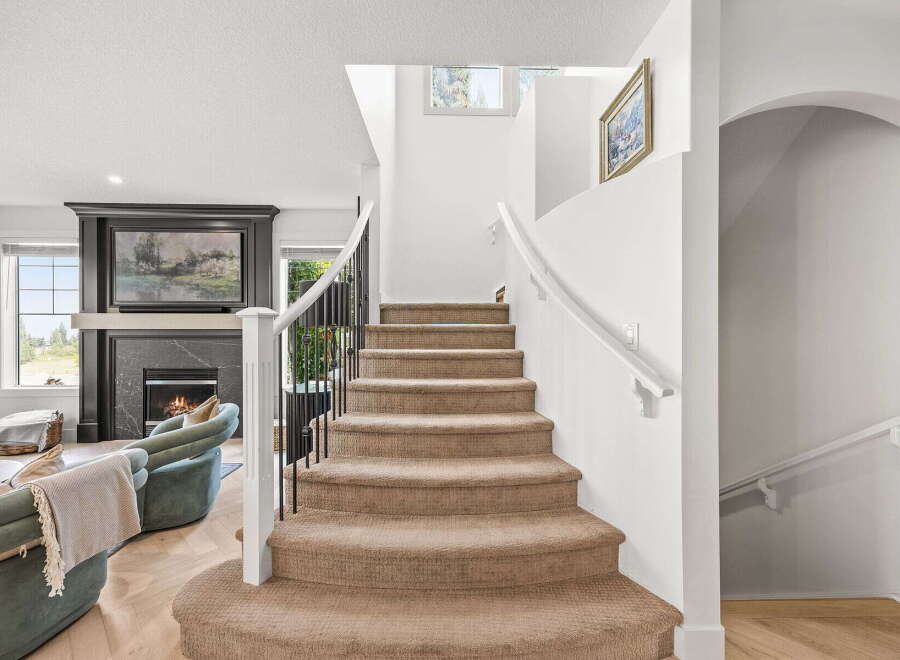 Step into luxury with this stunning home featuring a grand staircase and a cozy living area.