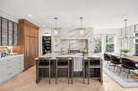 Experience luxury in this stunning modern kitchen, featuring a grand island with marble backsplash and elegant pendant lighting.