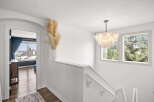 Ascend to the upper level of this stunning home via a beautifully lit staircase, adorned with a modern chandelier.