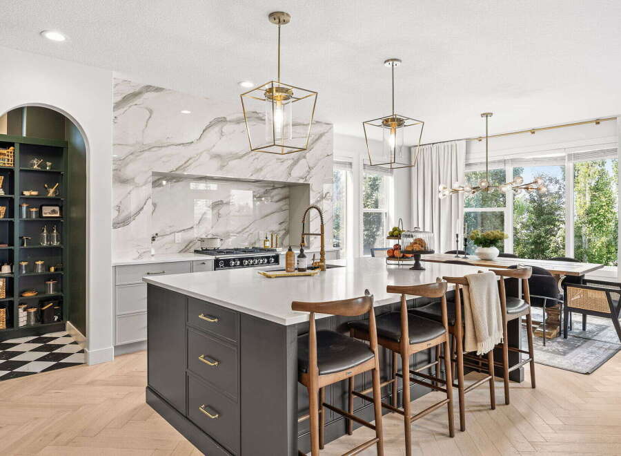 Experience luxury in this stunning modern kitchen, featuring a sleek marble backsplash and a spacious island perfect for entertaining.