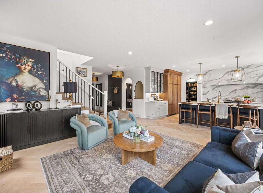Experience luxurious open-concept living in this stunning home, featuring a grand living area with a statement art piece and comfortable seating.