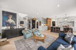 Experience luxurious open-concept living in this stunning home, featuring a grand living area with a statement art piece and comfortable seating.