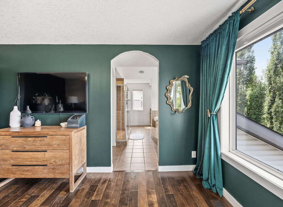 Step into a beautifully designed living space featuring a modern flat-screen TV mounted above a stylish wooden dresser.