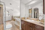 Indulge in luxury with this spacious bathroom featuring a large soaking tub and a separate glass-enclosed shower.