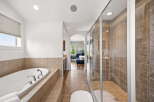 Indulge in luxury with this spacious master bathroom, featuring a deep soaking tub perfect for relaxation and a separate, beautifully tiled walk-in shower.