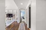 Step into this inviting hallway, featuring rich hardwood floors and a stylish runner leading to an arched doorway.