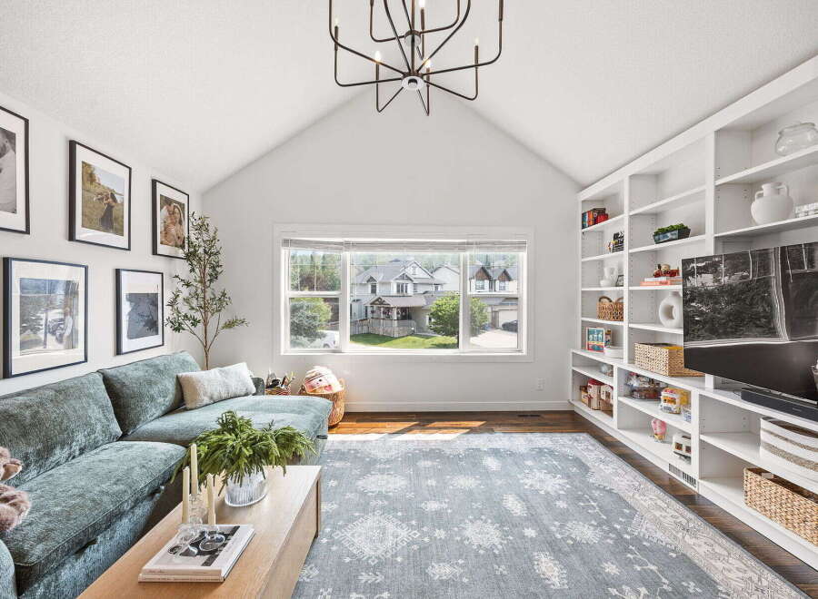 This inviting living room features a spacious sectional sofa, a modern coffee table, and a large area rug, perfect for family gatherings.