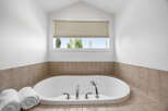 Indulge in relaxation in this luxurious bathroom featuring a spacious soaking tub, perfect for unwinding after a long day.
