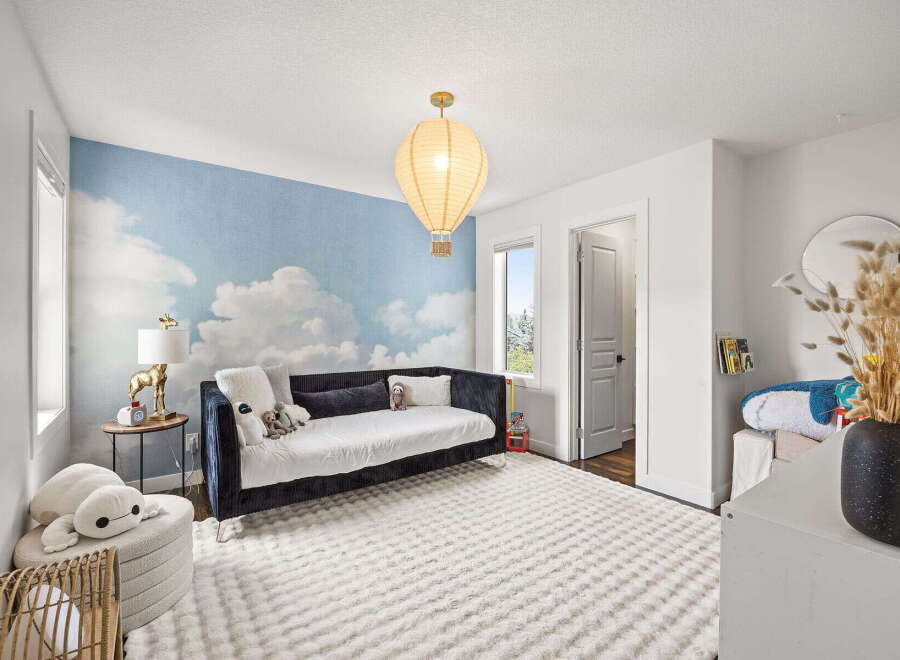 This charming bedroom features a whimsical cloud and hot air balloon wallpaper, creating a playful and dreamy atmosphere.