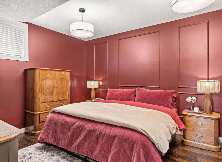 Experience luxurious comfort in this stunning bedroom, featuring a plush queen-size bed adorned with rich red velvet bedding and a complementary tan duvet.
