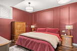 Experience luxurious comfort in this stunning bedroom, featuring a plush queen-size bed adorned with rich red velvet bedding and a complementary tan duvet.