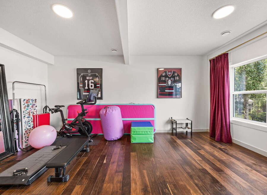 This home gym features a Peloton bike, a weight bench, and a large exercise ball, perfect for your fitness routine.