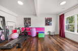 This home gym features a Peloton bike, a weight bench, and a large exercise ball, perfect for your fitness routine.