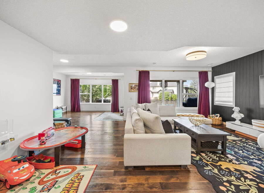 This spacious living area seamlessly blends a cozy family room with a dedicated play space, perfect for families.