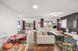 This spacious living area seamlessly blends a cozy family room with a dedicated play space, perfect for families.