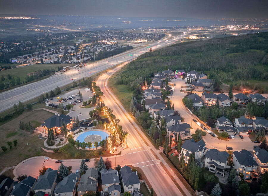 Experience luxury living in this stunning aerial view of a suburban neighborhood at dusk.