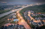 Experience luxury living in this stunning aerial view of a suburban neighborhood at dusk.