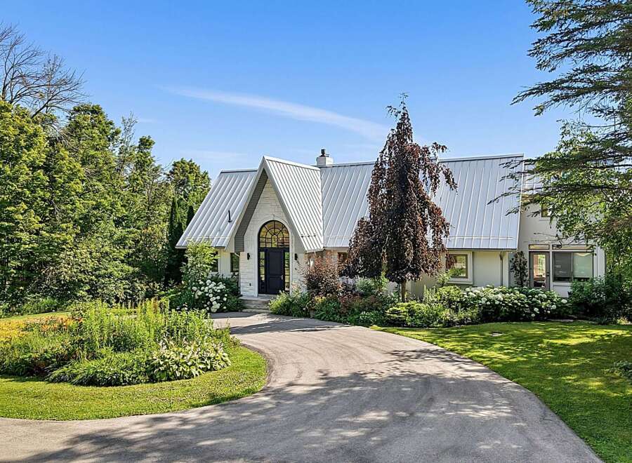 Discover this stunning home featuring a unique architectural design with a striking metal roof and an arched entryway.