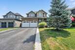 This stunning two-story home boasts a classic brick and stone facade, complemented by a well-maintained lawn and mature evergreen tree.