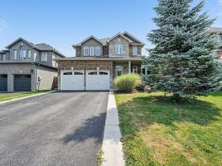 This stunning two-story home boasts a classic brick and stone facade, complemented by a well-maintained lawn and mature evergreen tree.