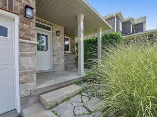 Welcome to this charming home featuring a welcoming covered porch with a classic lantern light and a prominent house number '19'.