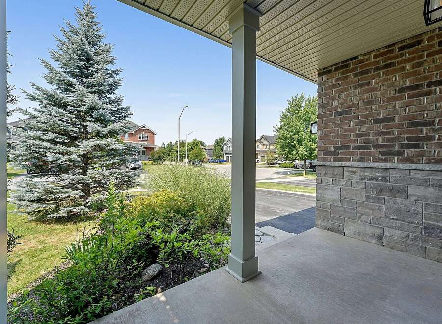 Welcome to this charming property featuring a welcoming porch with a sturdy pillar and a beautiful brick and stone exterior.