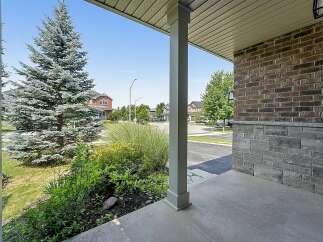 Welcome to this charming property featuring a welcoming porch with a sturdy pillar and a beautiful brick and stone exterior.