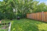 Enjoy outdoor living in this charming backyard, complete with a lush green lawn and a rustic fire pit perfect for cozy evenings.