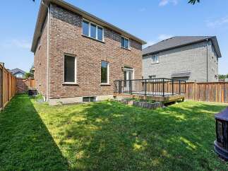 Enjoy outdoor living in this spacious backyard featuring a wooden deck perfect for entertaining and a lush green lawn.