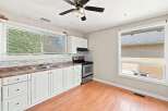Bright and functional kitchen featuring white cabinetry, a double sink, and a stainless steel gas range.