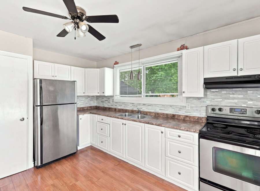 Discover this charming kitchen featuring sleek stainless steel appliances, including a refrigerator and a modern stove with a glass-top range.