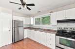 Discover this charming kitchen featuring sleek stainless steel appliances, including a refrigerator and a modern stove with a glass-top range.