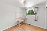 This bright and airy room features a large window with natural light flooding in, complemented by neutral gray curtains.