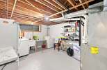 Discover the potential in this spacious basement laundry room, featuring a large utility sink, washer, and dryer.
