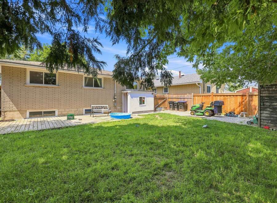 Enjoy outdoor living in this spacious backyard, complete with a lush green lawn perfect for recreation.