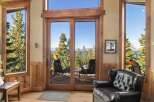 Experience breathtaking lake and mountain views from this stunning living space, featuring expansive windows and sliding glass doors that seamlessly blend indoor and outdoor living.