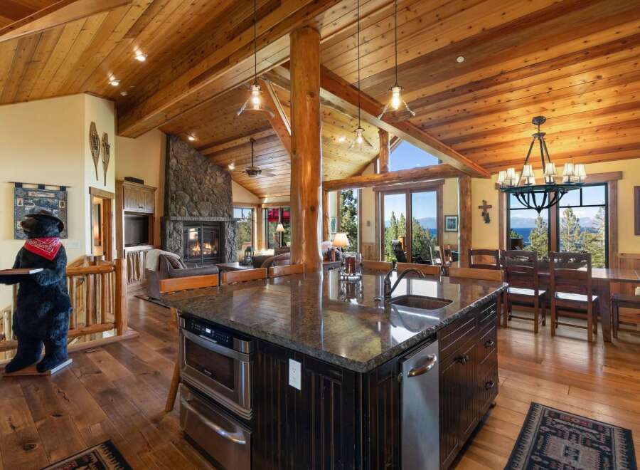 Experience luxury mountain living in this stunning home featuring a grand stone fireplace and vaulted wood-beamed ceilings.
