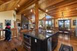 Experience luxury mountain living in this stunning home featuring a grand stone fireplace and vaulted wood-beamed ceilings.