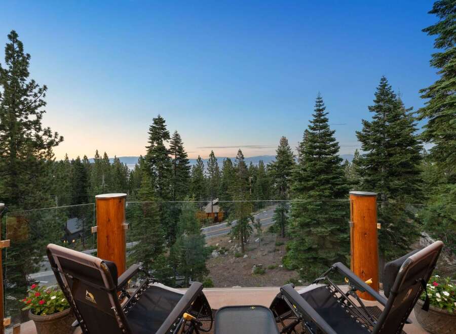 Enjoy breathtaking views from this stunning property, featuring a spacious balcony with comfortable lounge chairs perfect for relaxation.